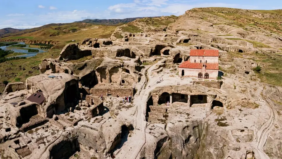 Aerial view of the rock-cut cave town of Uplistsikhe with its red-roofed church