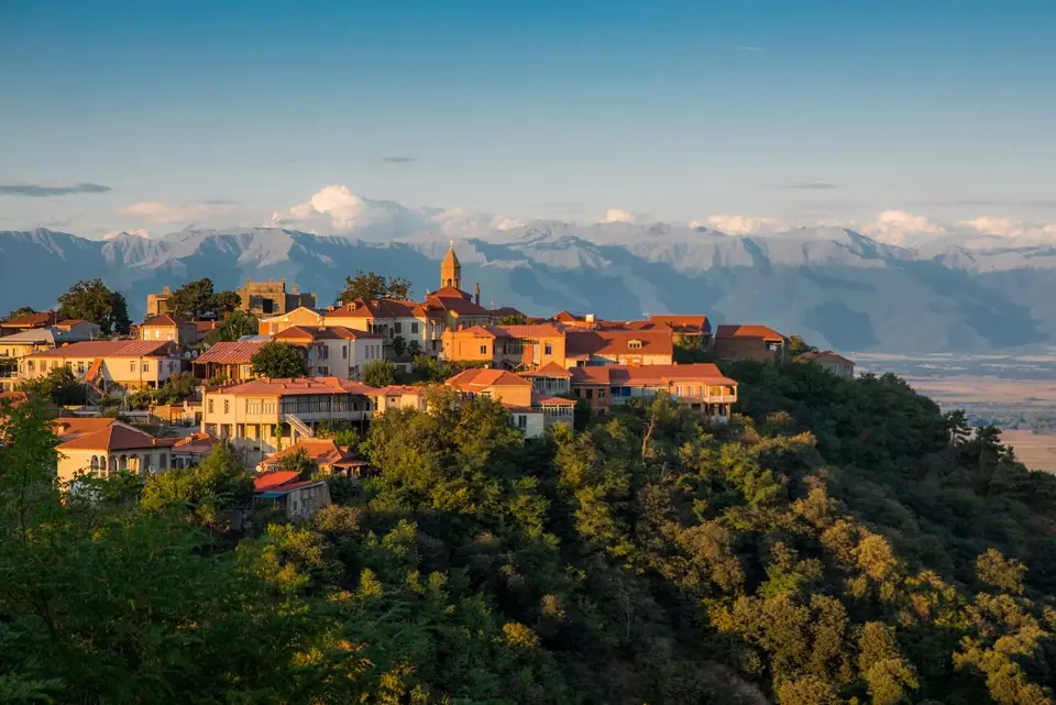 Sighnaghi's terracotta roofs on a hill with the Caucasus range behind