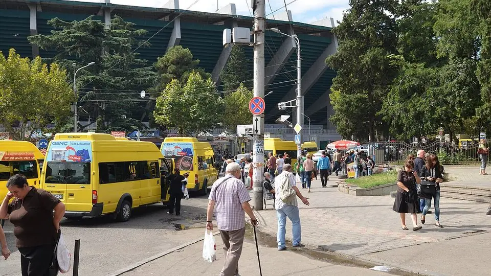 Yellow marshrutka minibuses waiting at a stop by the Dinamo Arena in Tbilisi