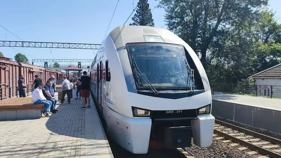 Georgian Railway Stadler train waiting at a station platform with passengers on benches
