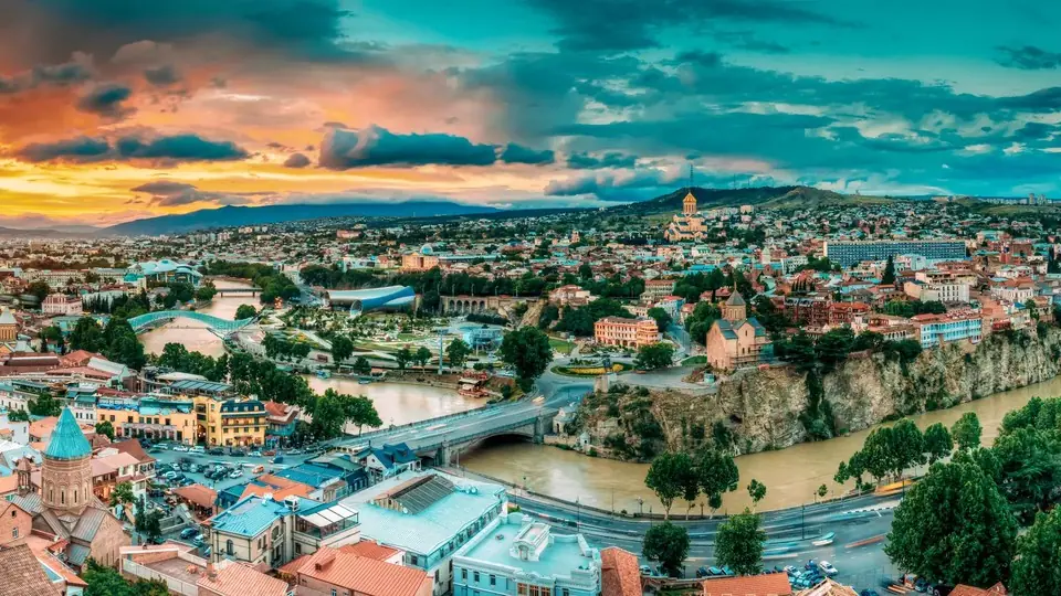 Aerial view of Old Tbilisi, Metekhi cliff and the river under a colourful sunset sky