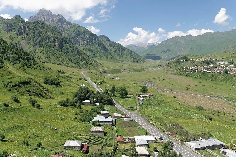 The Georgian Military Road running through the green Khevi valley past Sioni village and houses