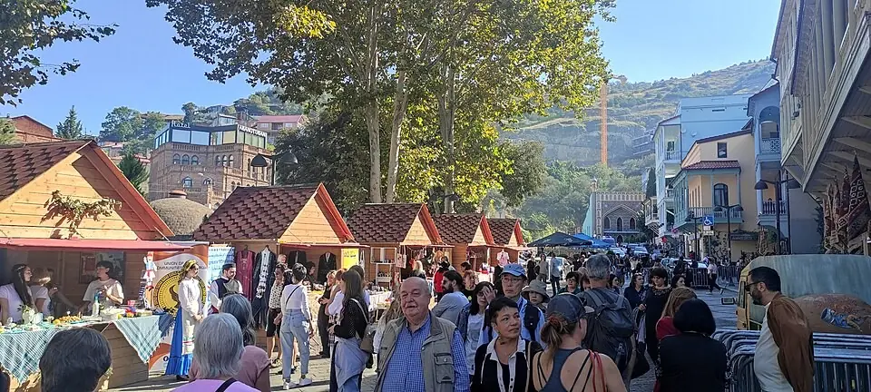 Толпы гуляют мимо деревянных праздничных лотков в Абанотубани во время Тбилисобы