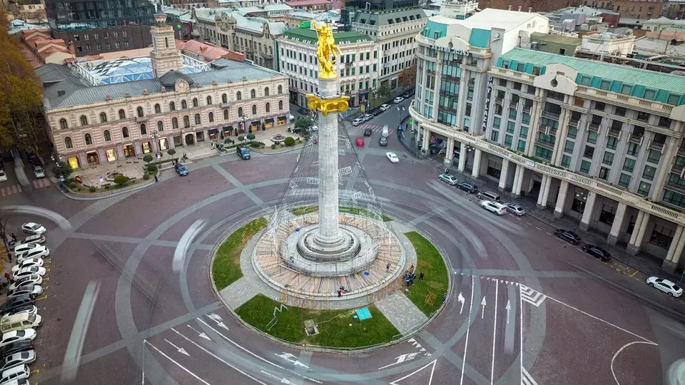 Aerial view of Freedom Square in Tbilisi, its column, roundabout and blurred passing traffic