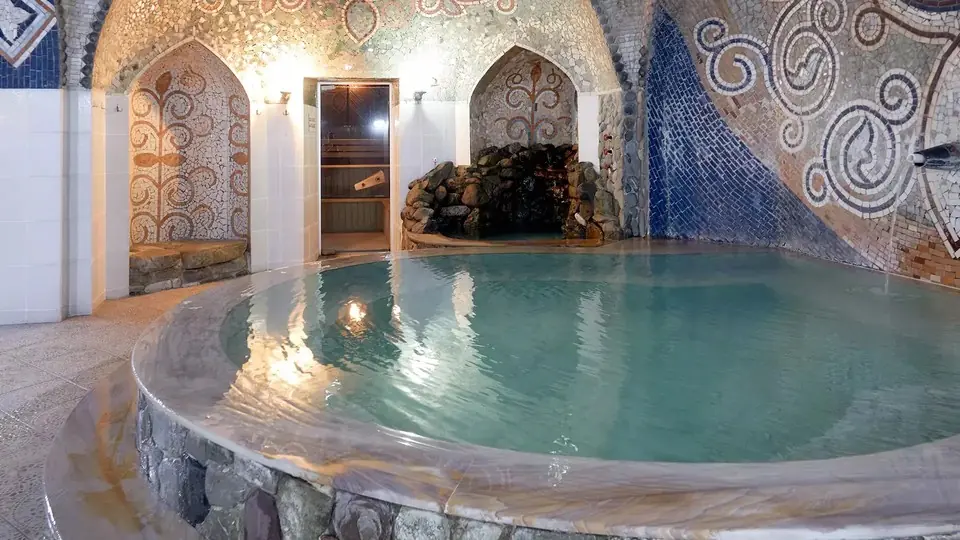 Private room in a Tbilisi sulphur bath with a round stone pool and mosaic walls