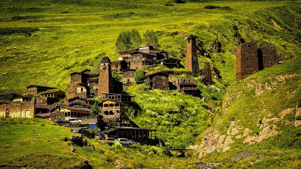 Stone tower houses with wooden balconies in a Tusheti village on a green slope