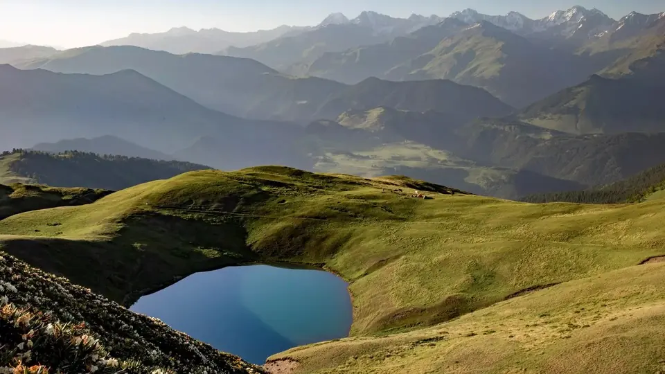 Oreti Lake in a grassy hollow on the ridge, layered Tusheti mountains behind