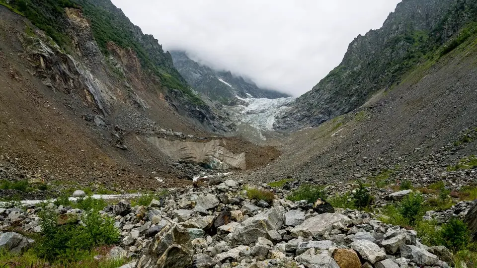 Boulder-strewn valley above Mazeri leading up to the Ushba Glacier tongue under cloud